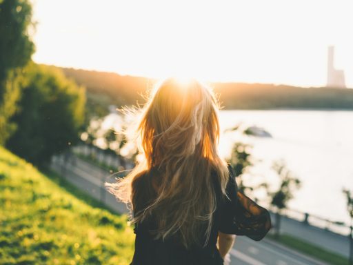 woman sitting while looking at the sunset