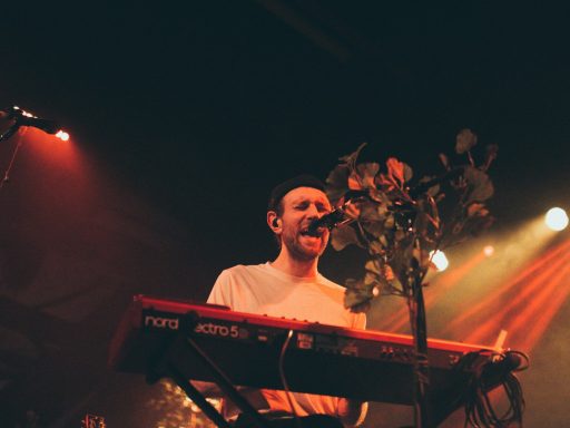 man sings while playing keyboards