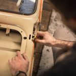 A man adjusting the lock mechanism on a car door