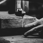 grayscale photography of person cutting slab