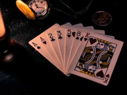 A dimly lit close-up of playing cards with a pocket watch, showcasing a nostalgic casino vibe.