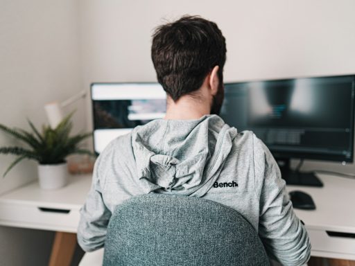 man in gray hoodie sitting on chair