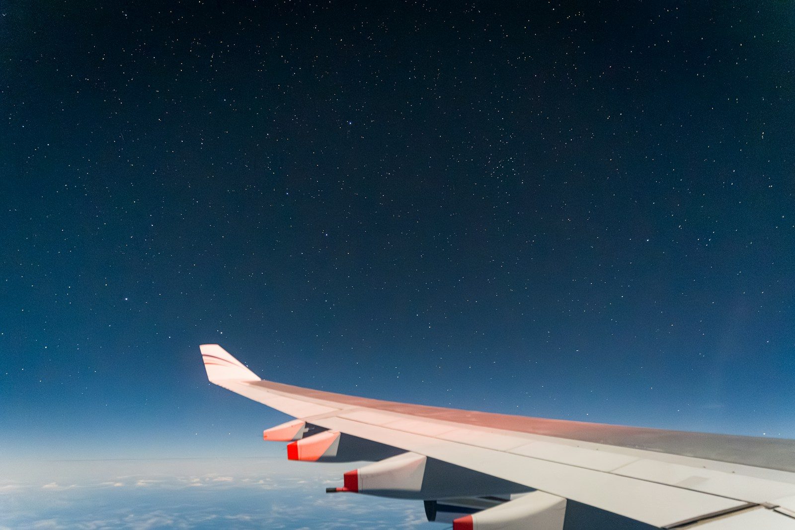 Airplane wing against a starry night sky