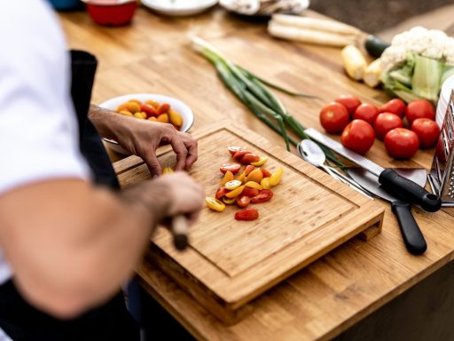 a person cutting up vegetables on a cutting board