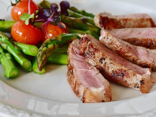 Bord met kleurrijke groenten zoals zoete aardappel, boerenkool en wortelen, rijk aan bètacaroteen