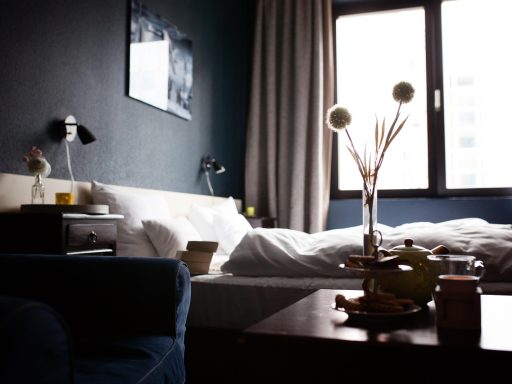 Alleenreizende persoon in een hotelkamer met een koffer naast het bed