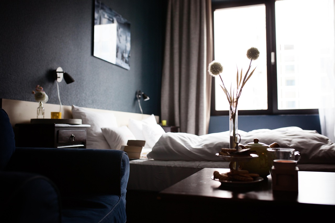 Alleenreizende persoon in een hotelkamer met een koffer naast het bed