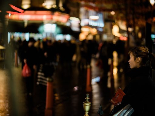 Een persoon met rugzak die alleen door een Europese stadsstraat wandelt