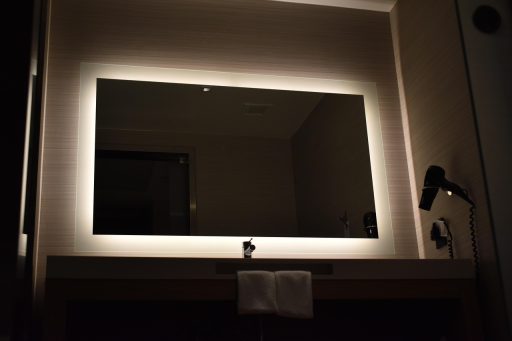 Verlichte badkamerspiegel met frontverlichting boven een wastafel