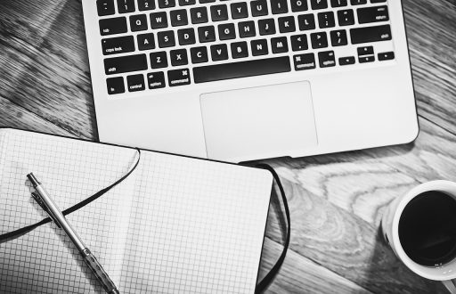 Houten bureaublad in een thuiskantoor met monitor en laptop