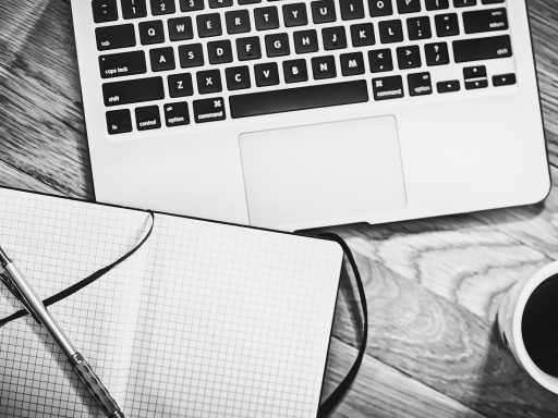 Houten bureaublad in een thuiskantoor met monitor en laptop