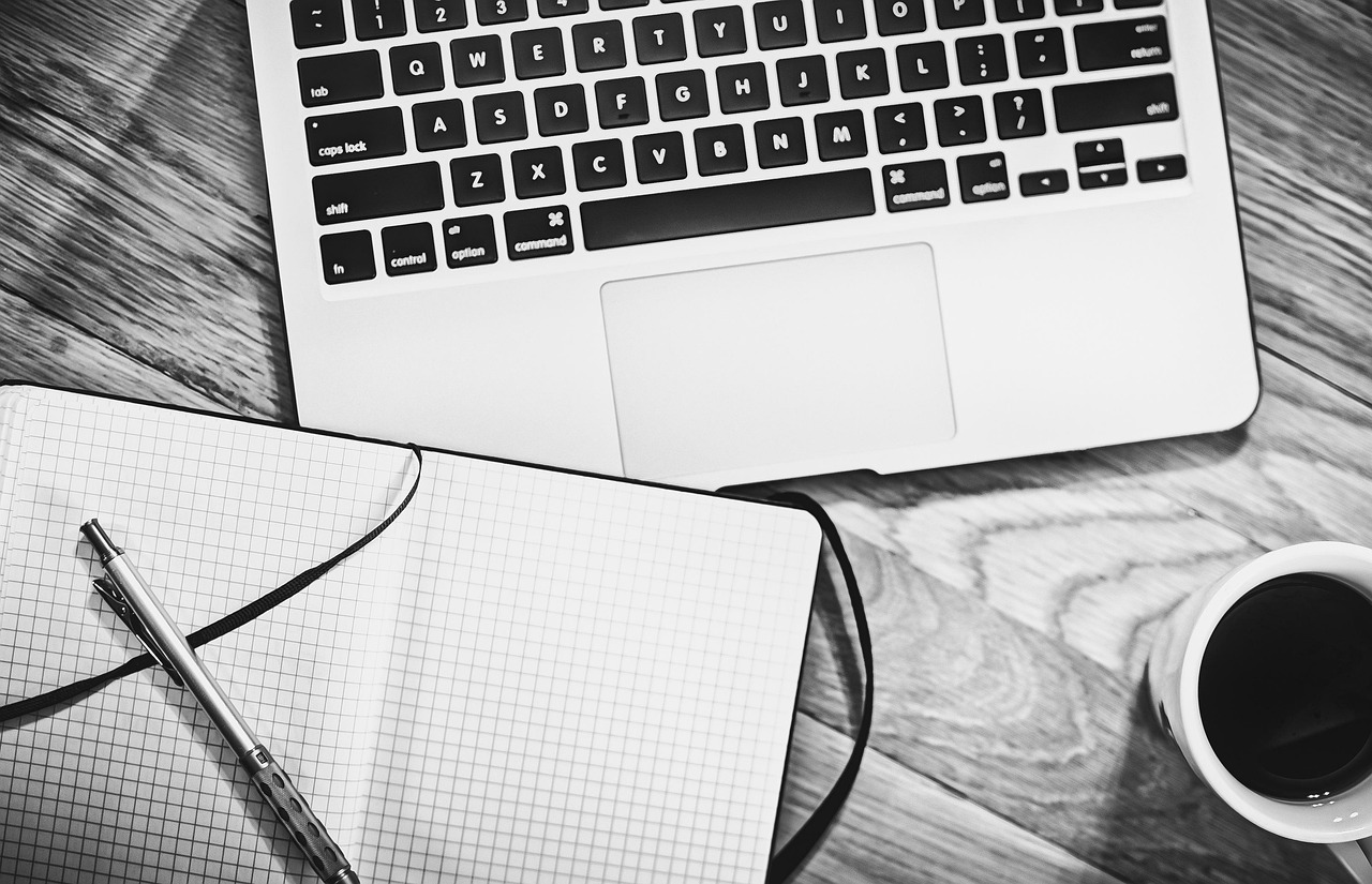 Houten bureaublad in een thuiskantoor met monitor en laptop