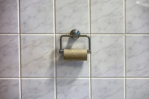 Opgezwollen en verkleurde wandpanelen in een vochtige badkamer als gevolg van vochtschade