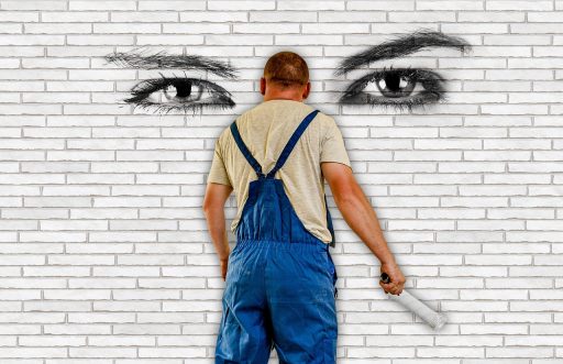 Persoon die een muur schildert met een verfroller tijdens renovatie