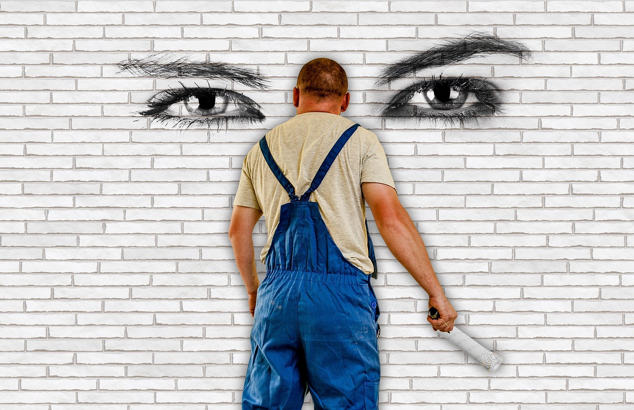 Persoon die een muur schildert met een verfroller tijdens renovatie