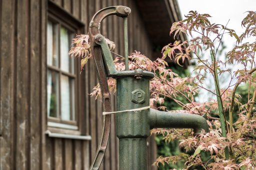 Buitenunit van een lucht-water warmtepomp naast een woonhuis