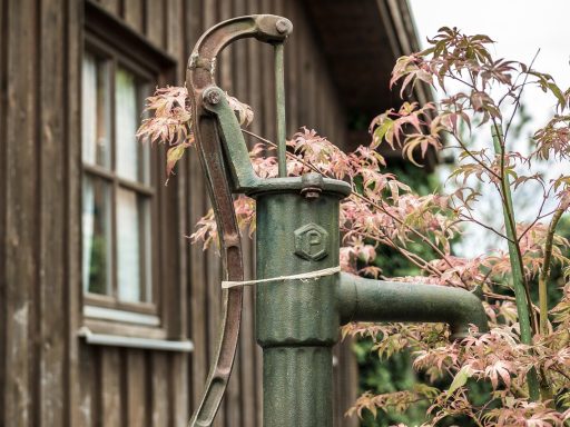 Buitenunit van een lucht-water warmtepomp naast een woonhuis